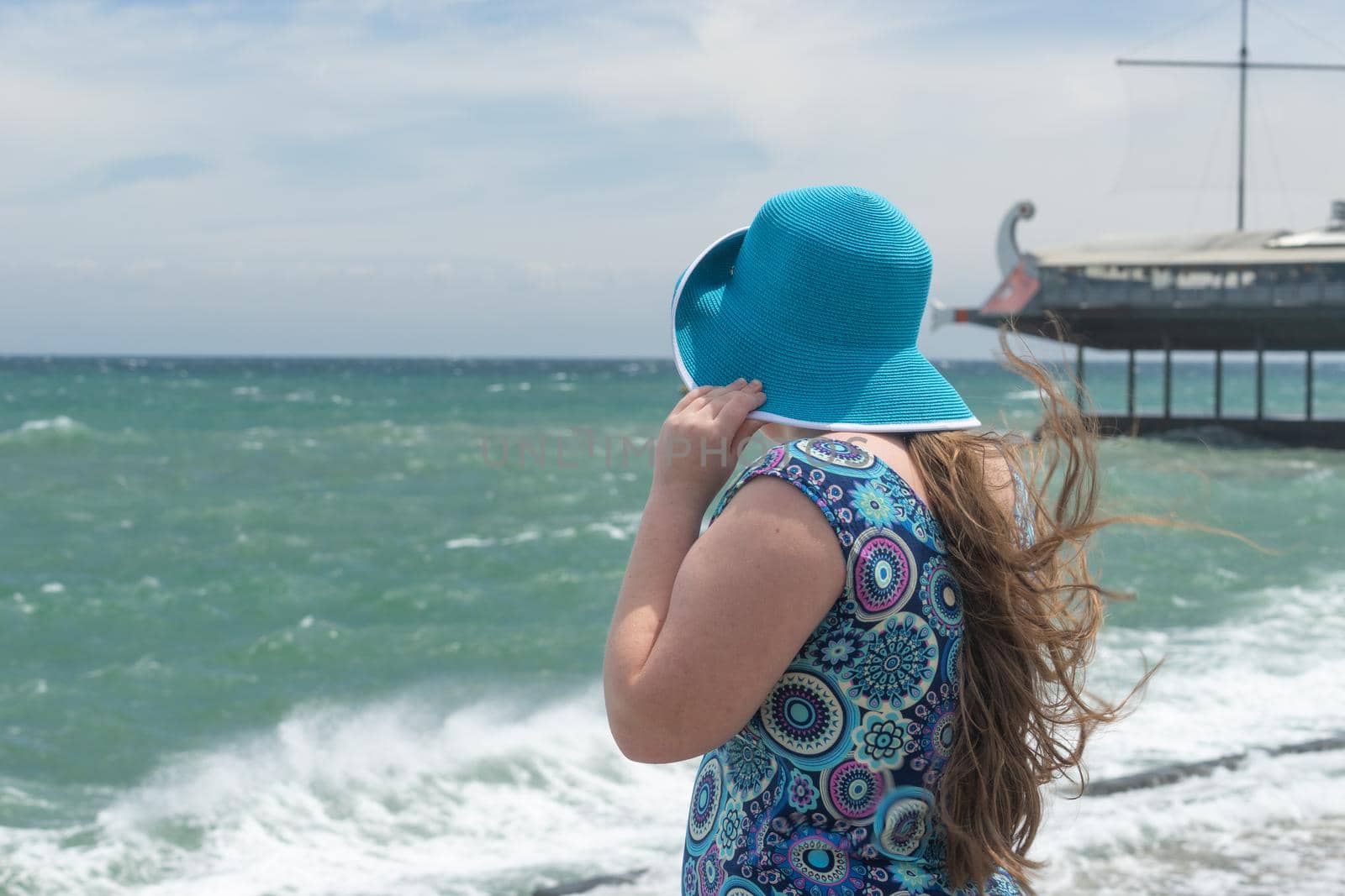 Yalta, Crimea. The girl in the blue hat on the blurred background of the seascape.