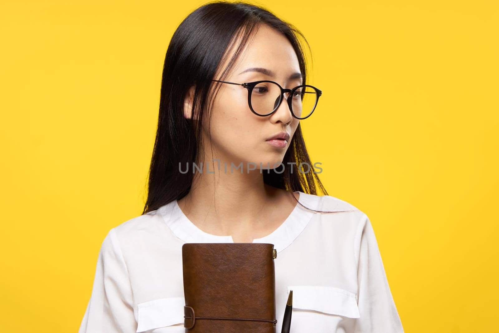 Business woman in glasses holding notepad in hands official yellow isolated background. High quality photo