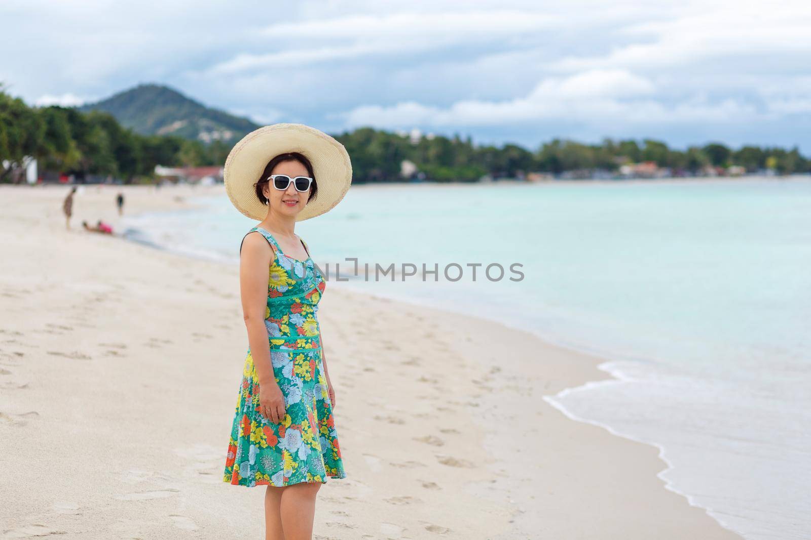Asian middle aged woman relaxing at chaweng beach in koh samui ,Thailand.