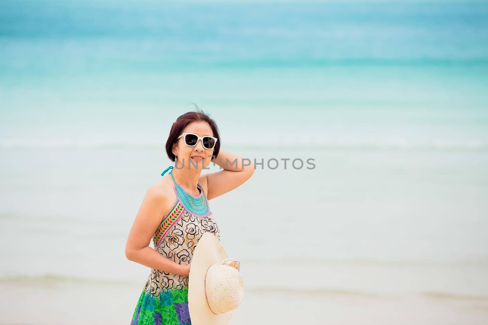 Asian middle aged woman relaxing at chaweng beach in koh samui ,Thailand.