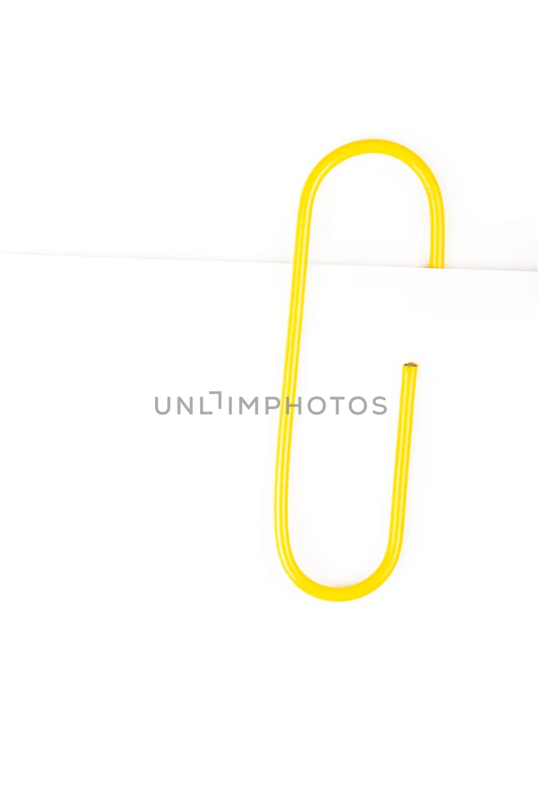 yellow paper clip on a white background