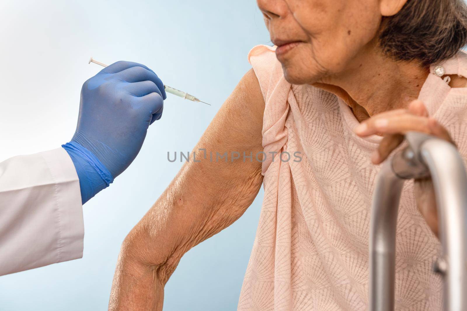 Doctor doing vaccine injection to senior woman. by toa55