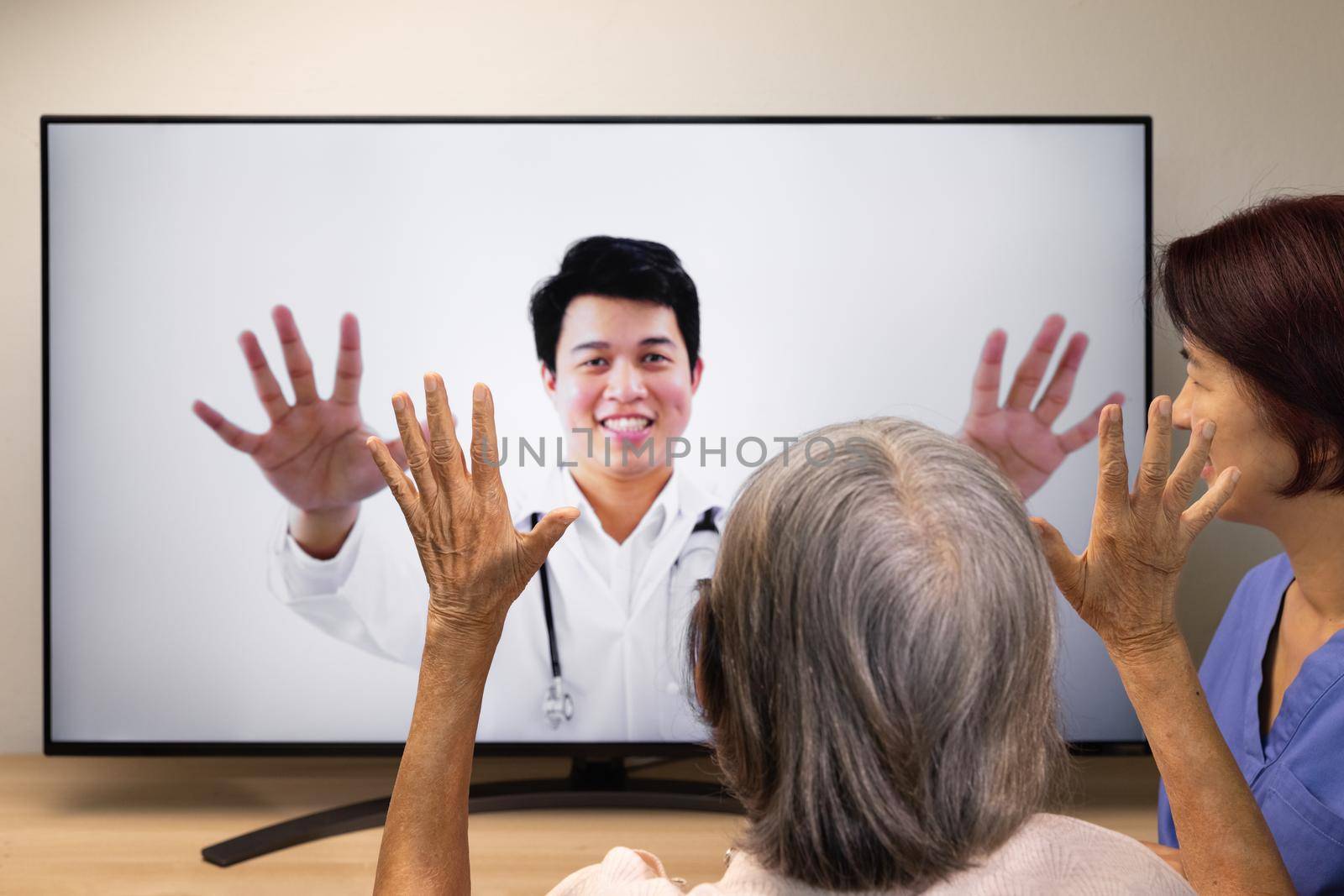 Elderly woman using physical therapy online service at home. by toa55