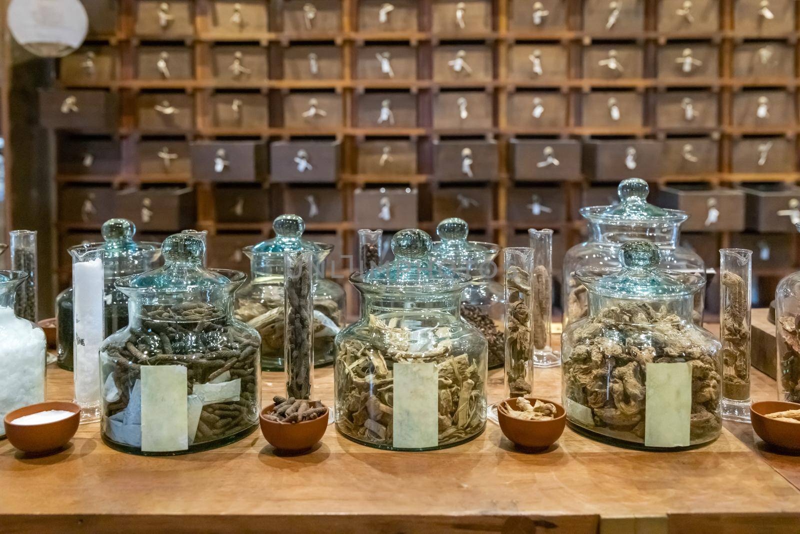 Traditional chinese pharmacy shop. Ancient herbs pharmacy cabinet wooden drawers in background