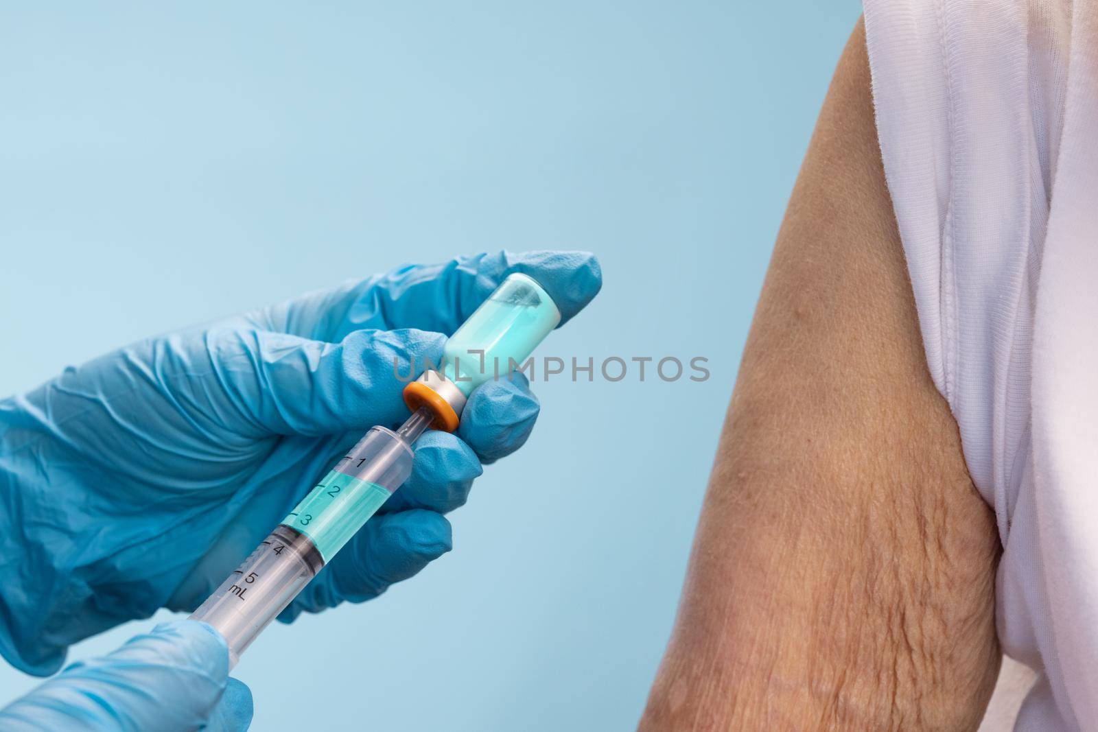 Closeup nurse doing vaccine injection to senior woman. by toa55