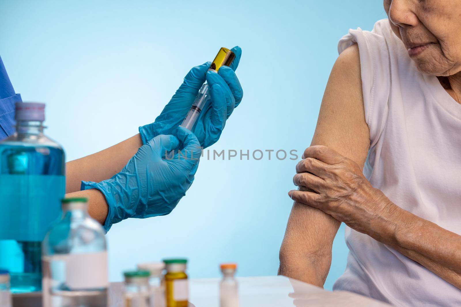 Closeup nurse doing vaccine injection to senior woman. by toa55