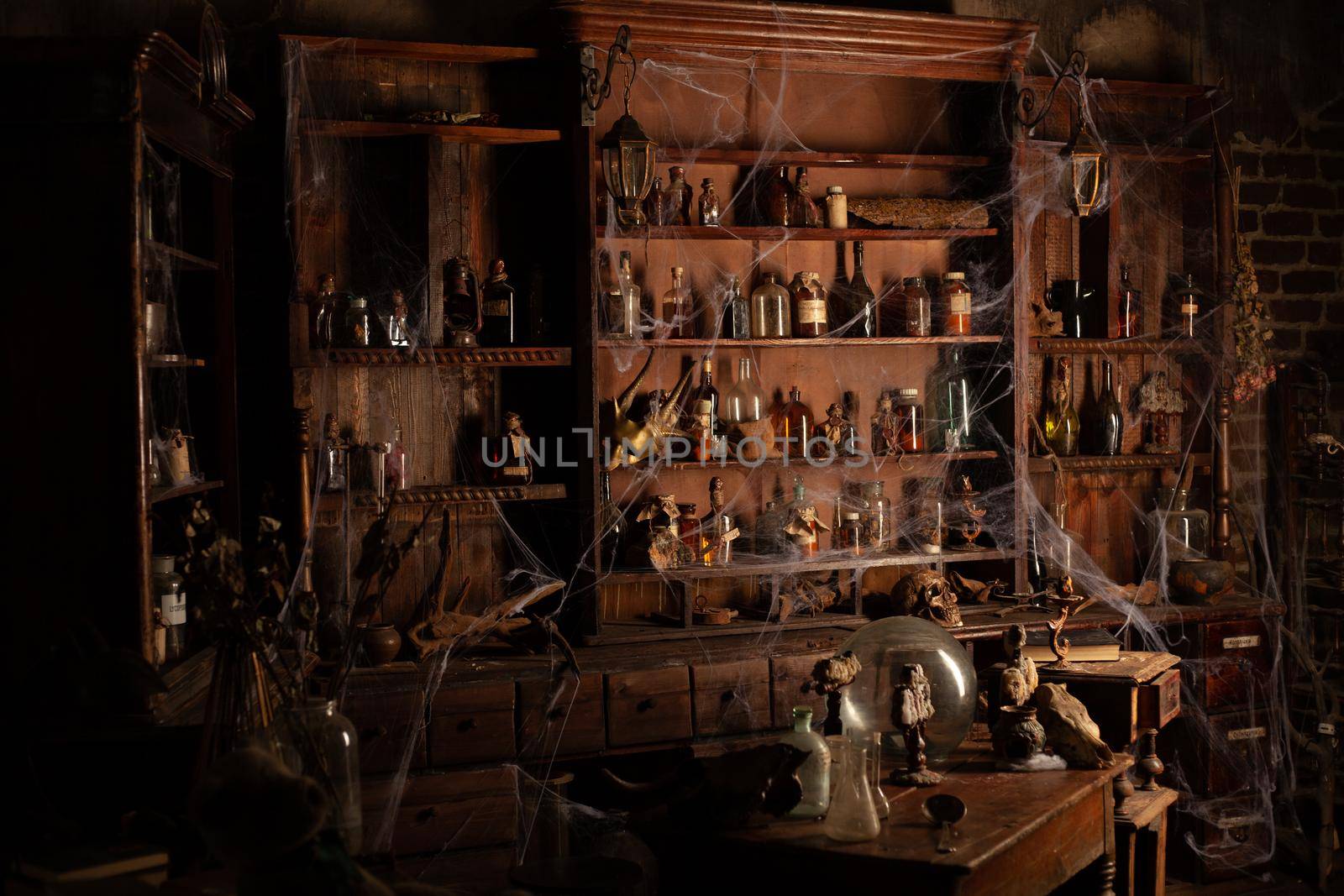 Halloween background Shelves with alchemy tools Skull spiderweb bottle with poison candles Witcher workspace Scarry room