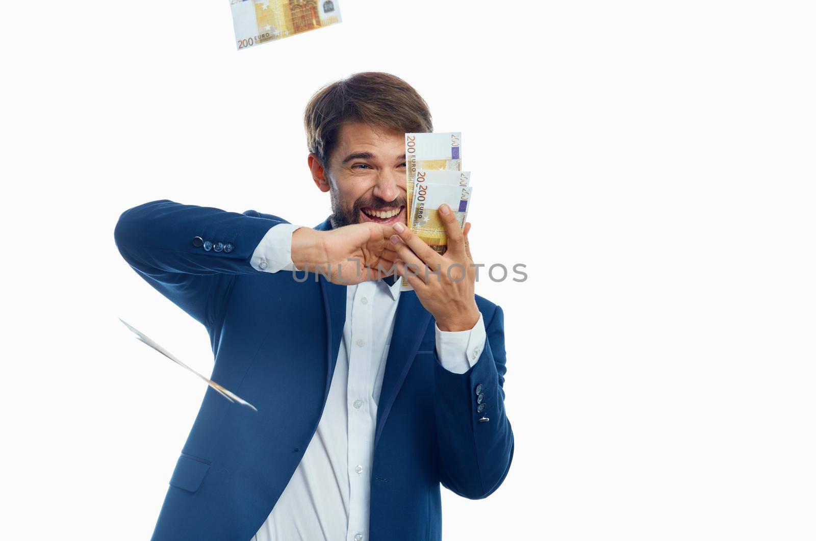 happy man scatter money on light background suit model business finance. High quality photo