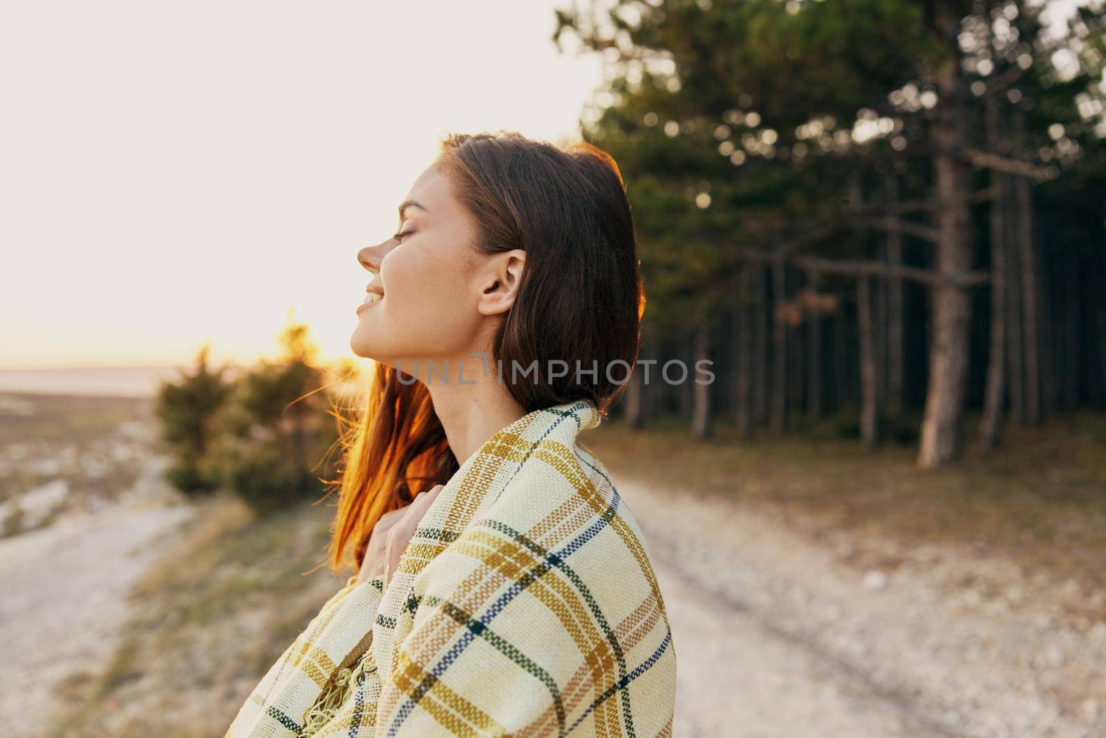 traveler with a blanket on her shoulders fresh air conifers nature forest. High quality photo