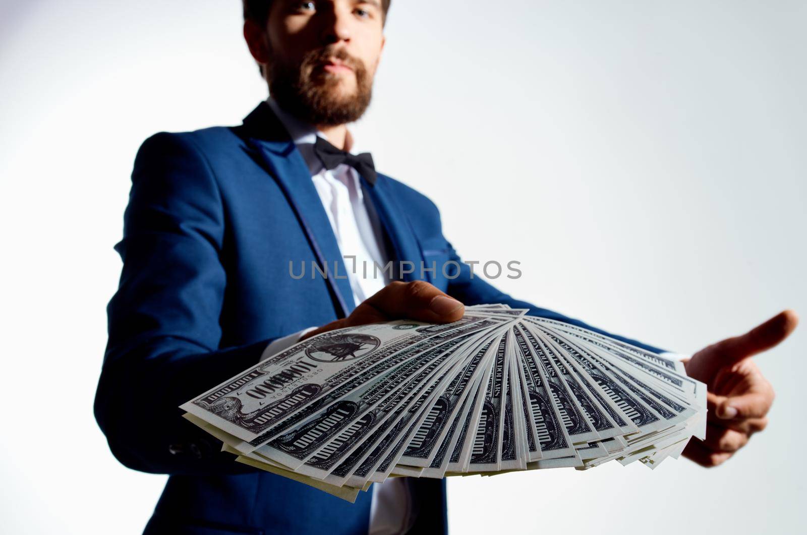 rich guy with a stack of bills money classic suit gesturing with his hands. High quality photo