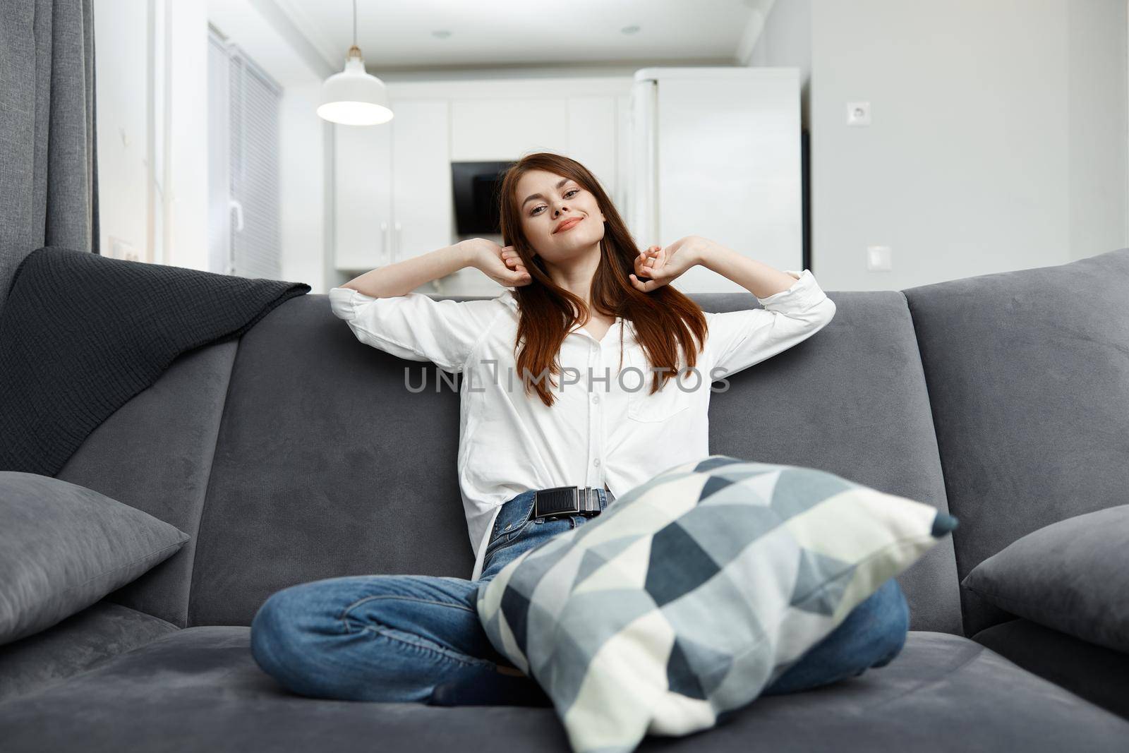 woman with pillow in comfortable sofa at home interior by SHOTPRIME