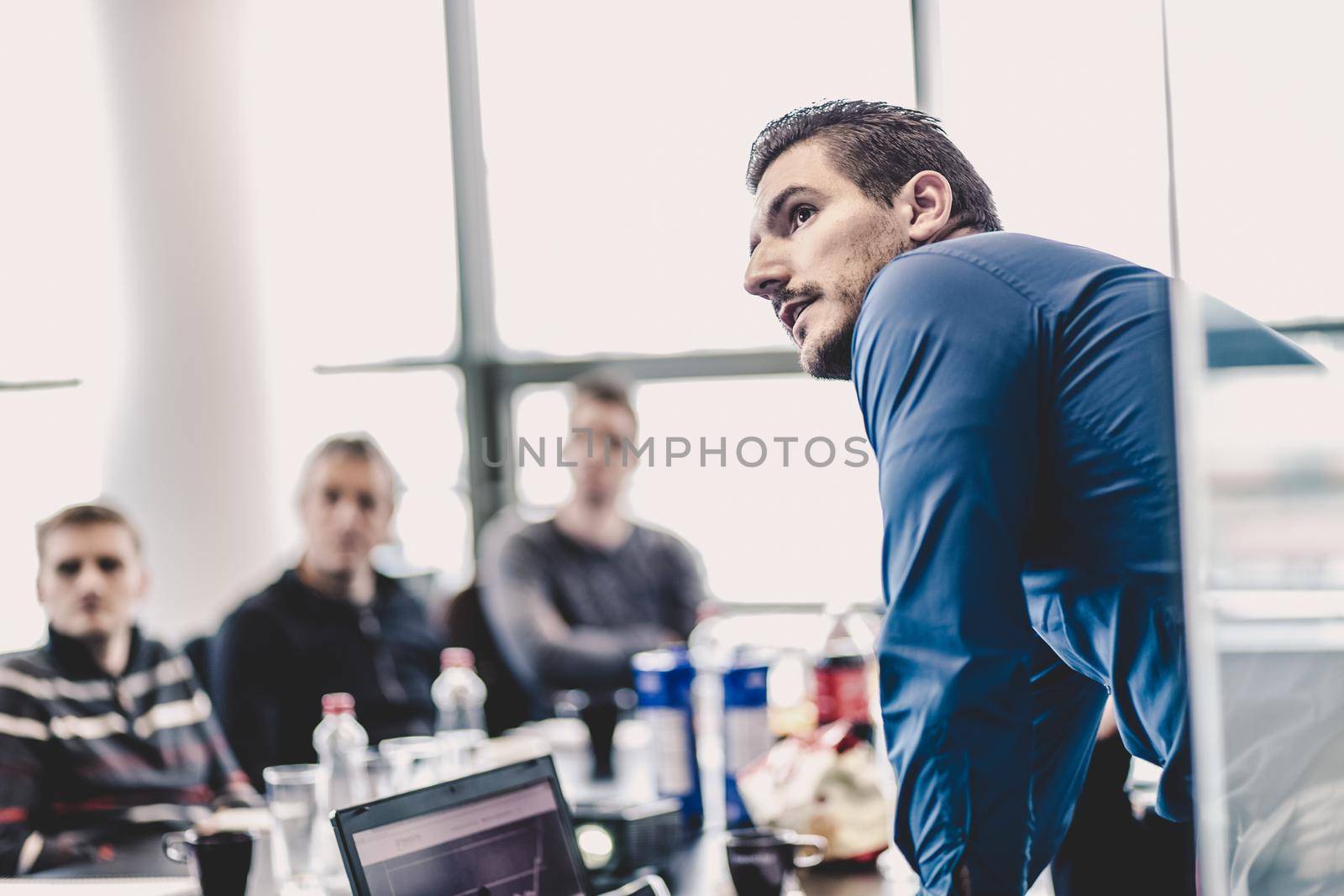 Businessman making a presentation at office. Business executive delivering a presentation to his colleagues during meeting or in-house business training, explaining business plans to his employees.