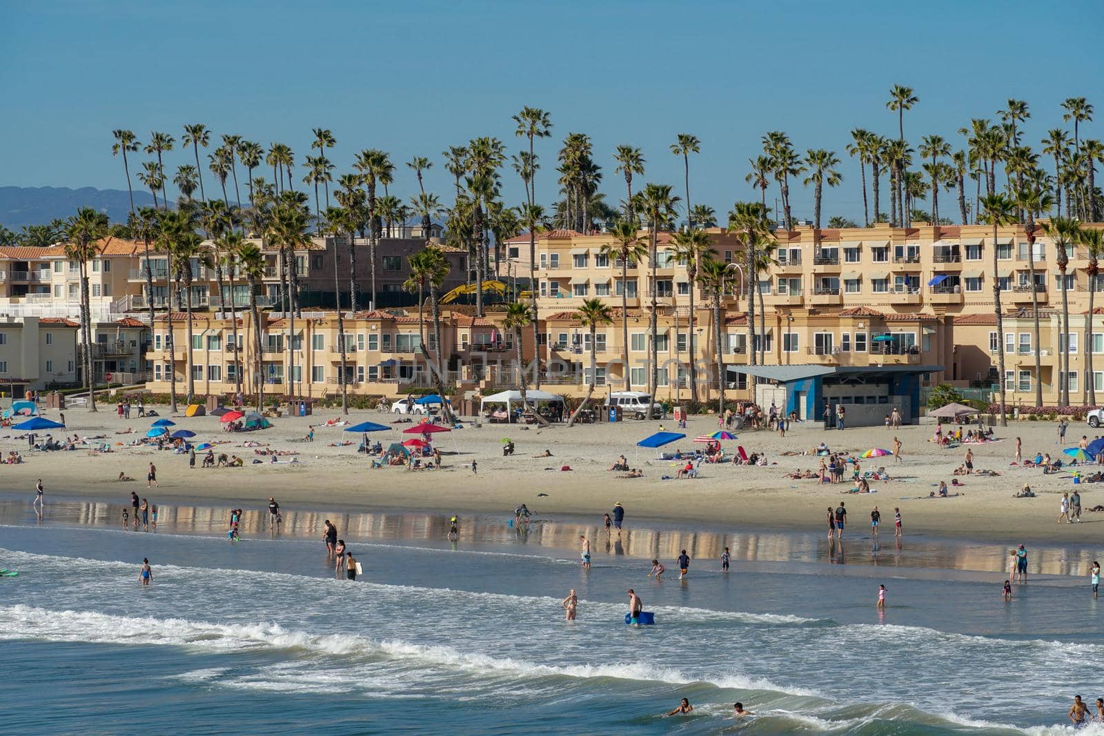 People on the beach enjoying beautiful summer day at Oceanside beach in San Diego, California. 