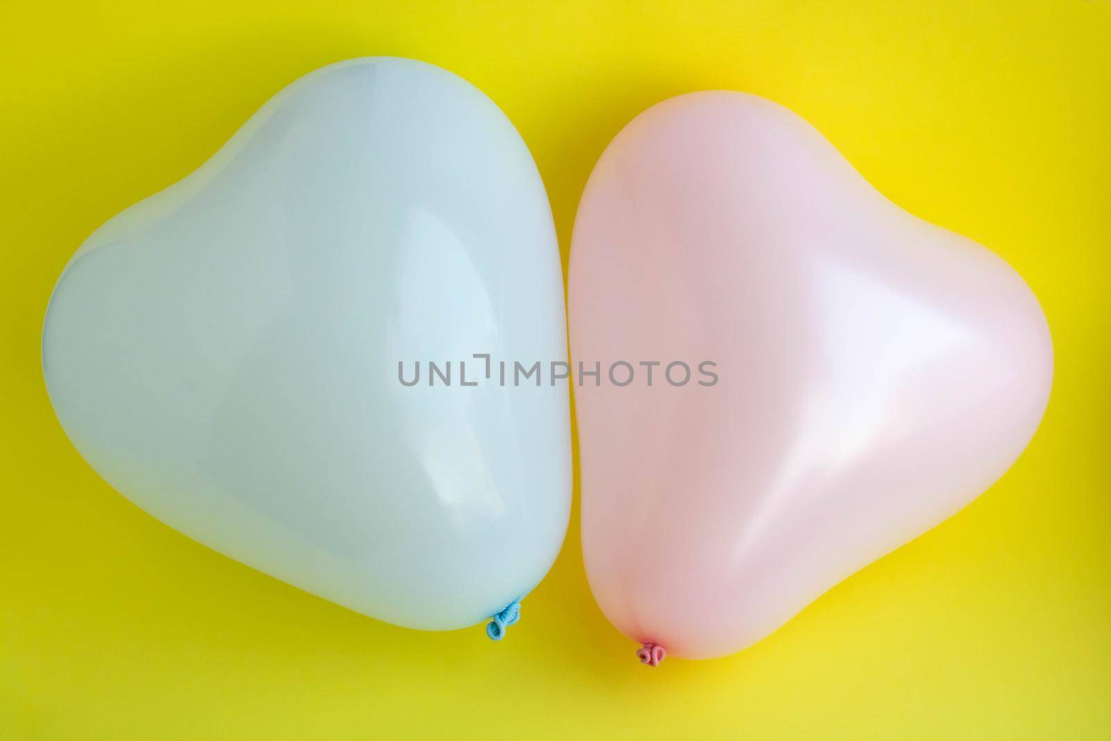 Blue and pink balloons in the shape of a heart on a yellow background. Wedding concept, Valentine's Day, photo zone, lovers. Banner. top view