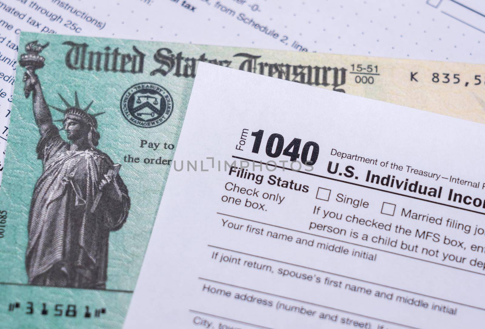 US Treasury stimulus check laying on a form 1040 tax return for 2020 to illustrate questions about qualification for payment