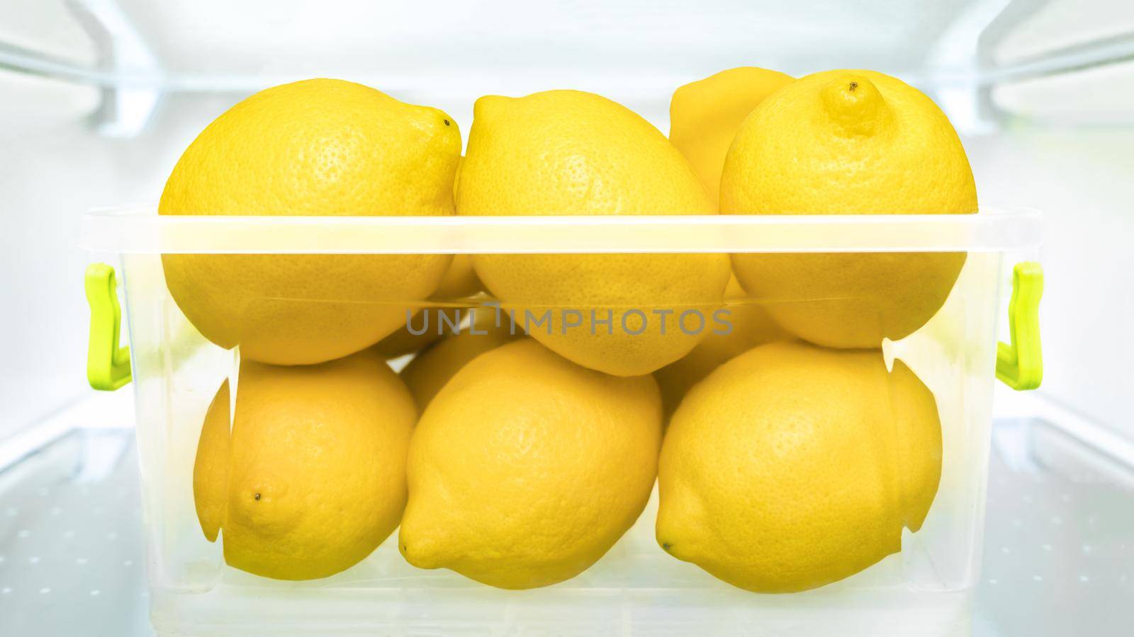 Cool lemon fridge lemonade detox juice ripe fruit in plastic box refrigerator. Food storage containers lemons refrigerator healthy eating fresh fruits fridge stocking vitamin C immune system boosters by synel