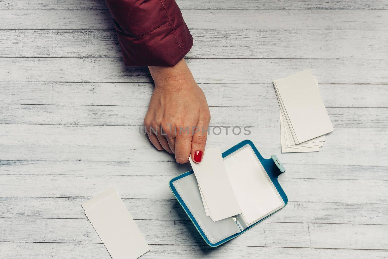 business card holder on a wooden table with white paper by SHOTPRIME