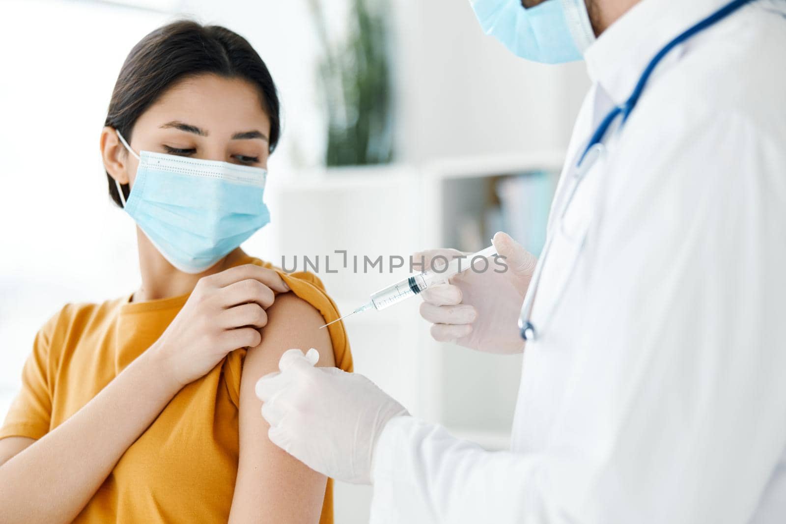 woman wearing a medical mask at the doctor's appointment covid-19 vaccination epidemic by SHOTPRIME