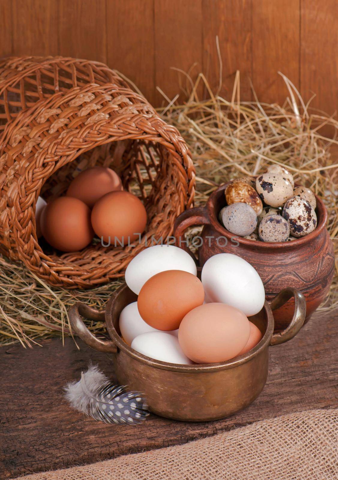 Brown eggs in wooden basket. Broken egg with yolk in background by aprilphoto