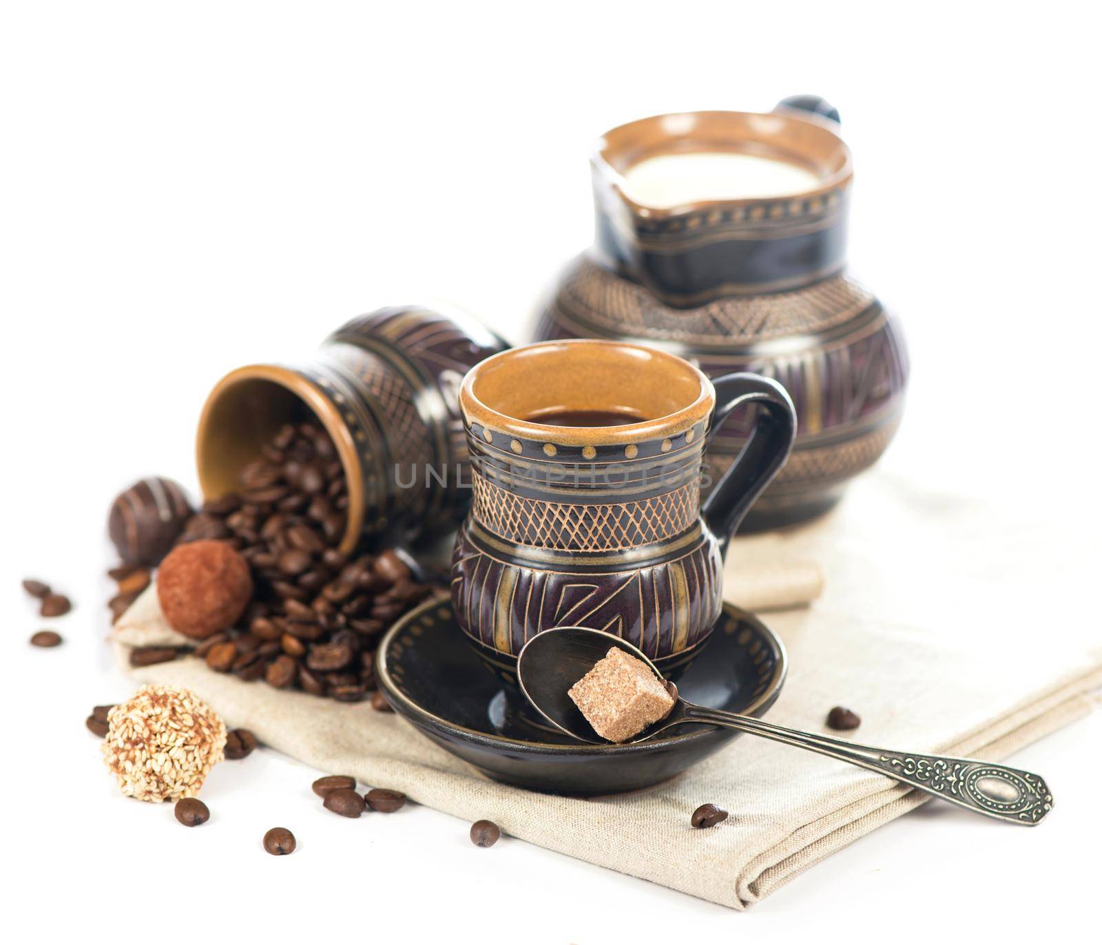 old black pottery, coffee beans, candy and a cup of drink by aprilphoto