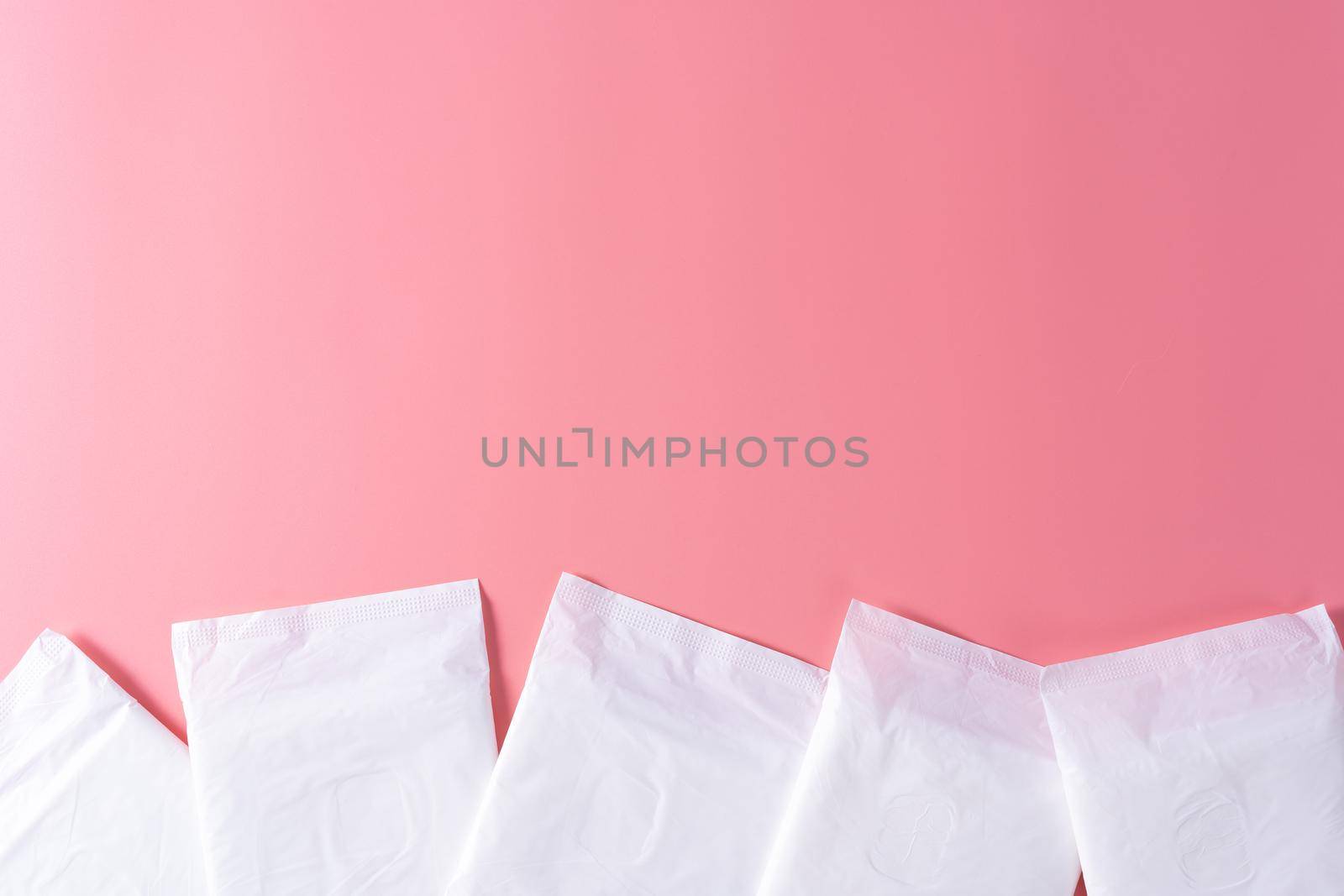 Sanitary pad, Sanitary napkin on pink background. Menstruation, Feminine hygiene, top view.