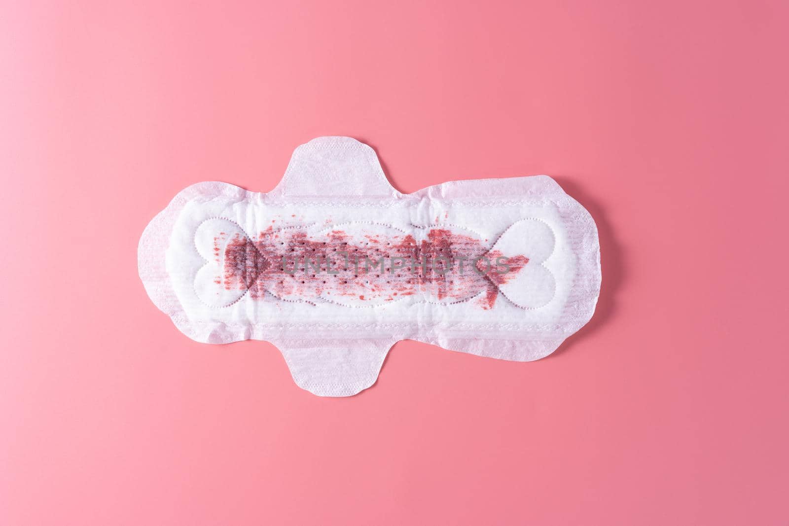 Used Sanitary pad with full amount of blood, Sanitary napkin on pink background. Menstruation, Feminine hygiene, top view.