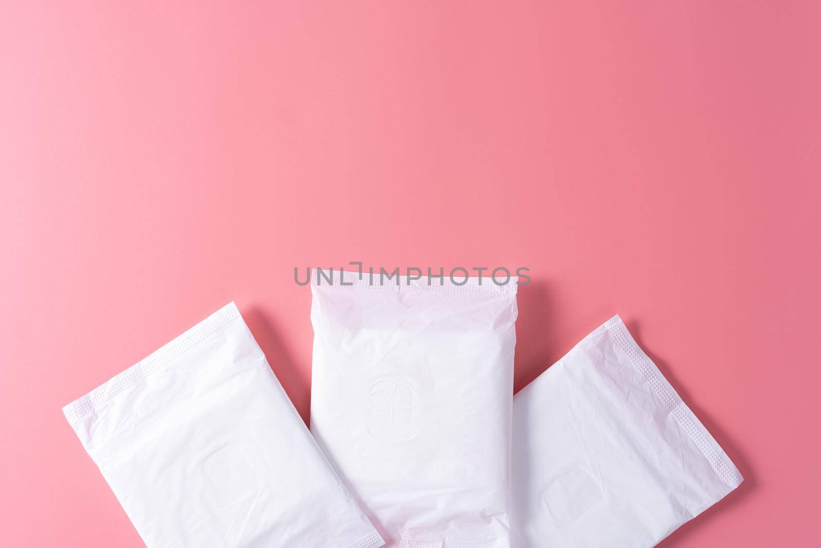 Sanitary pad, Sanitary napkin on pink background. Menstruation, Feminine hygiene, top view. by mikesaran