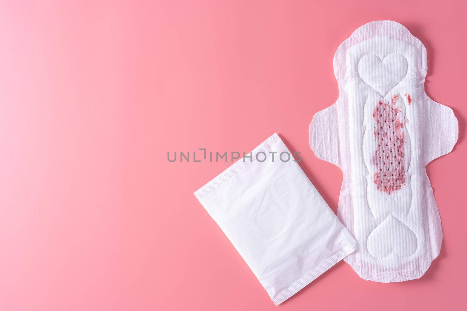 Used Sanitary pad, Sanitary napkin on pink background. Menstruation, Feminine hygiene, top view. by mikesaran