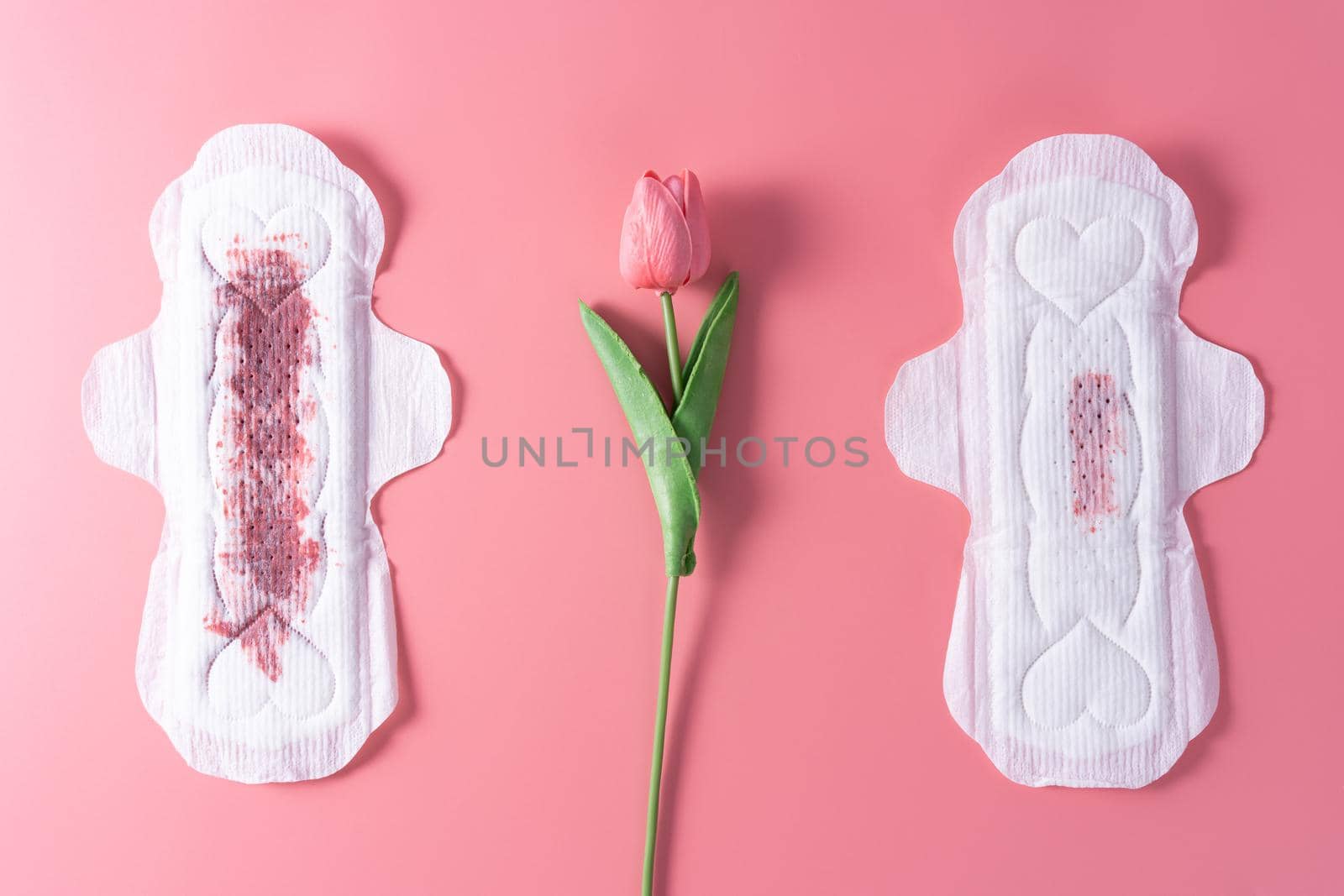 Set of different used sanitary pad, Sanitary napkin with tulip flower on pink background. Menstruation, Feminine hygiene, top view.