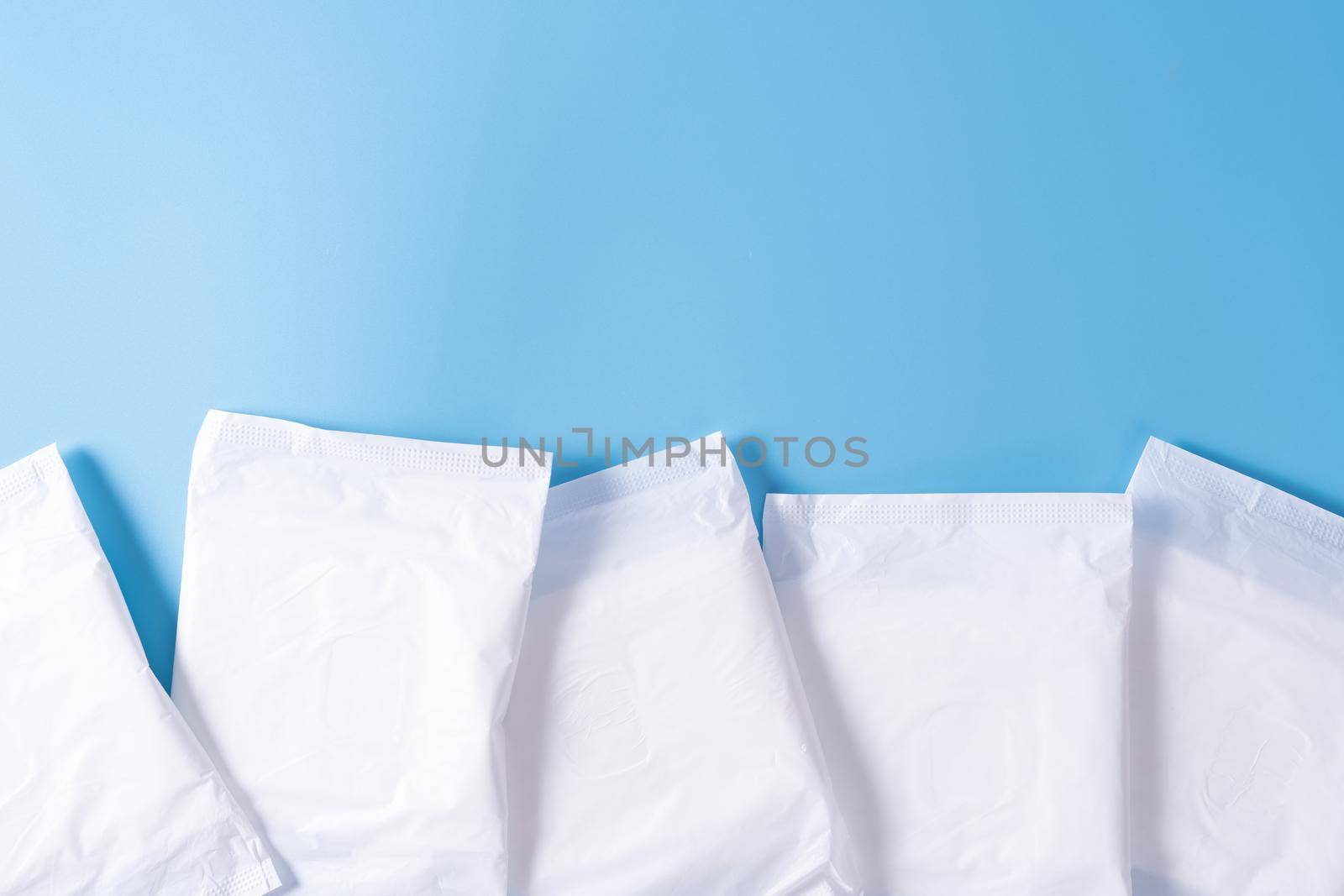 Sanitary pad, Sanitary napkin on blue background. Menstruation, Feminine hygiene, top view.