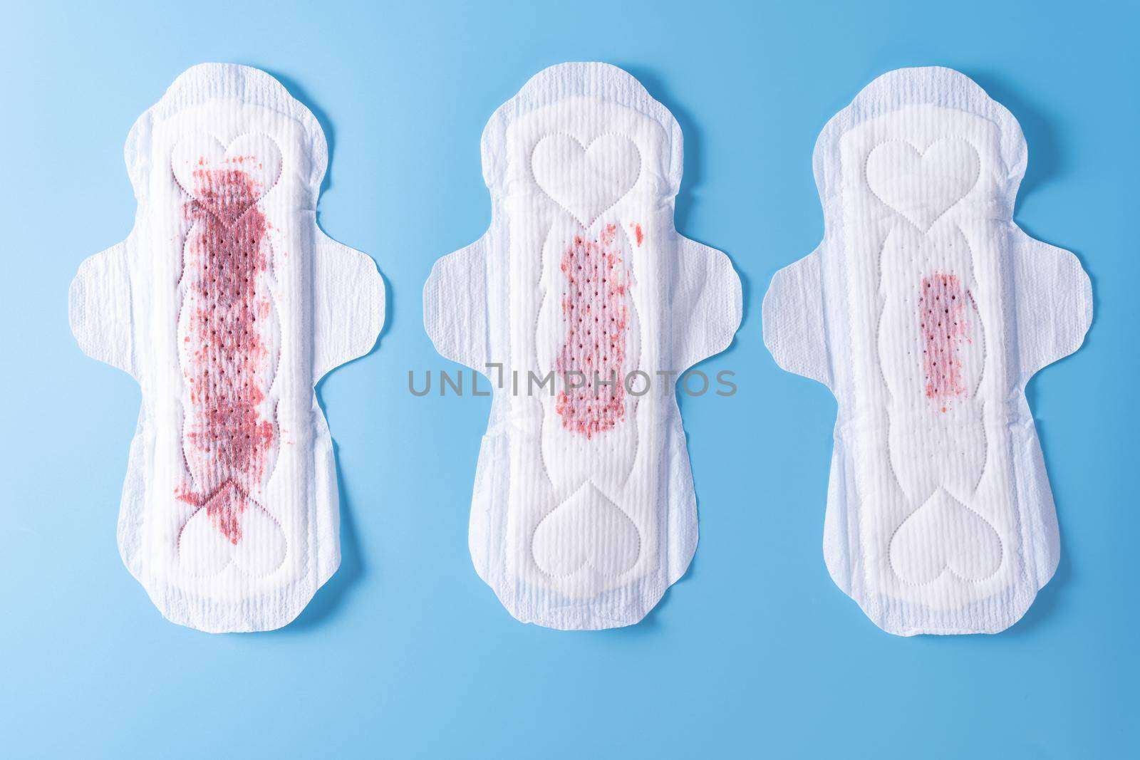 Set of different used sanitary pad, Sanitary napkin on blue background. Menstruation, Feminine hygiene, top view. by mikesaran
