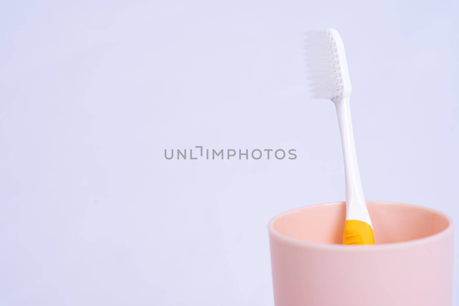 Closeup toothbrush in the glass isolated grey background. Copy space for text.