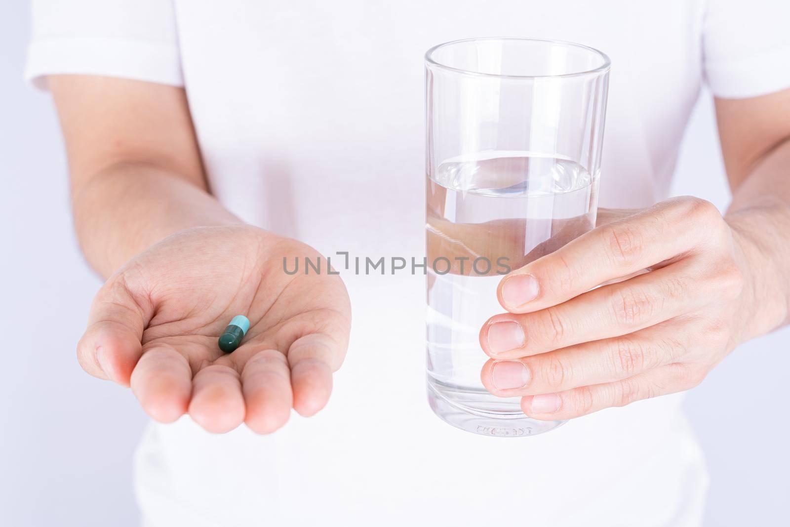Close up hands holding glass of water and pill drugs. Healthcare and medical pharmacy concept. by mikesaran