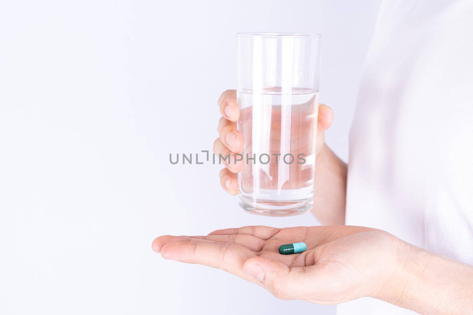 Close up hands holding glass of water and pill drugs. Healthcare and medical pharmacy concept. by mikesaran