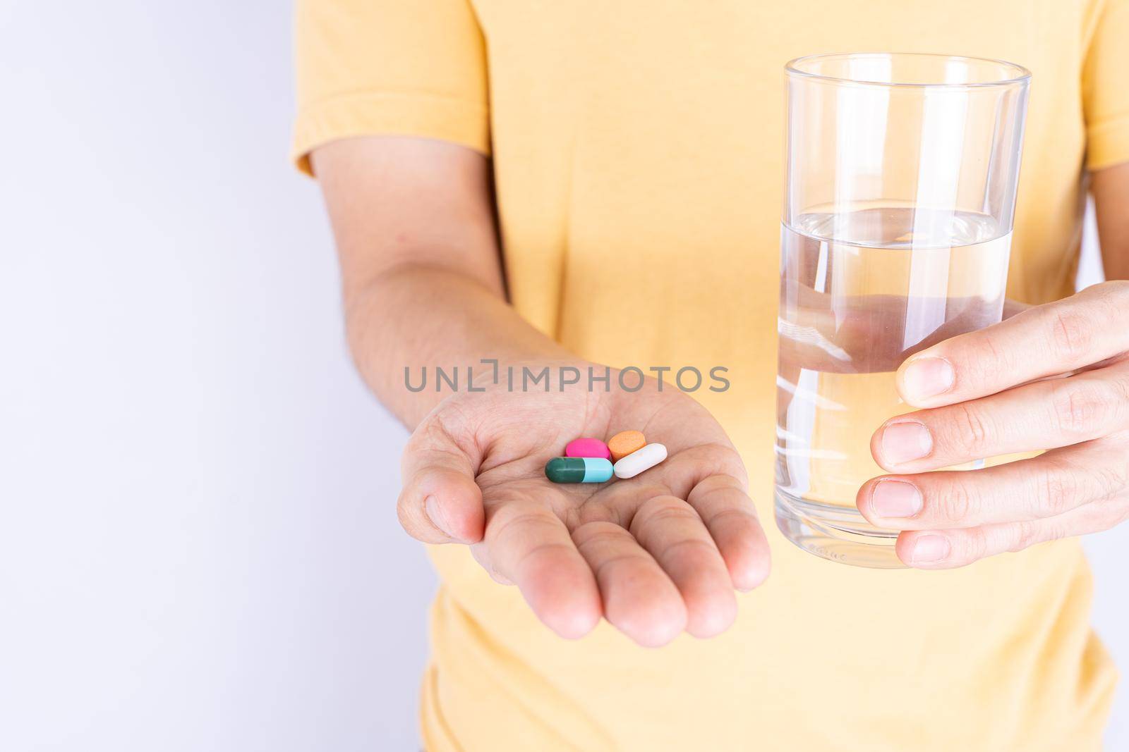 Close up hands holding glass of water and pill drugs. Healthcare and medical pharmacy concept. by mikesaran