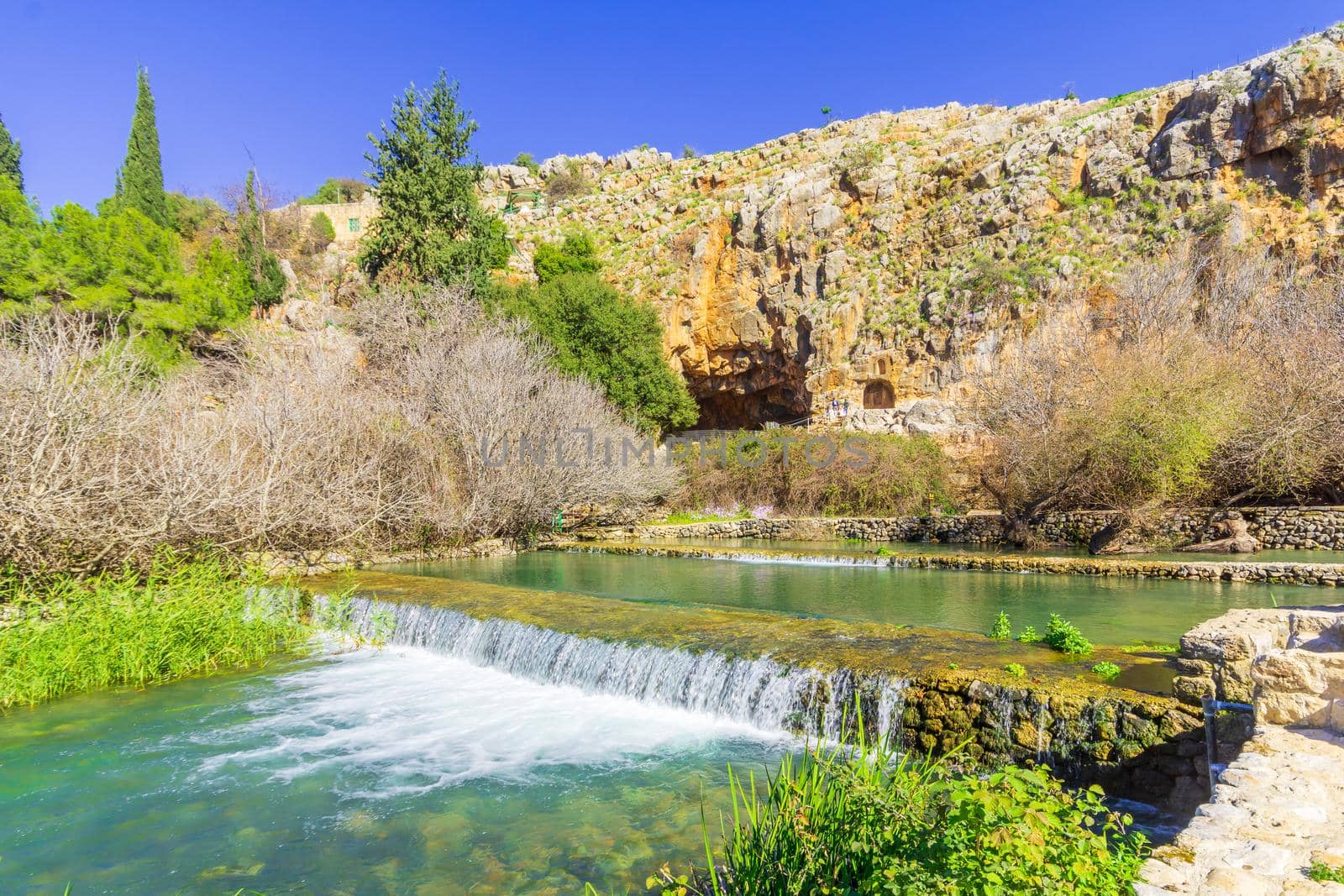 View of a water stream, with the remains of the Shrine and Cave of Pan in the background, in the Hermon Stream (Banias) Nature Reserve, Upper Galilee, Northern Israel