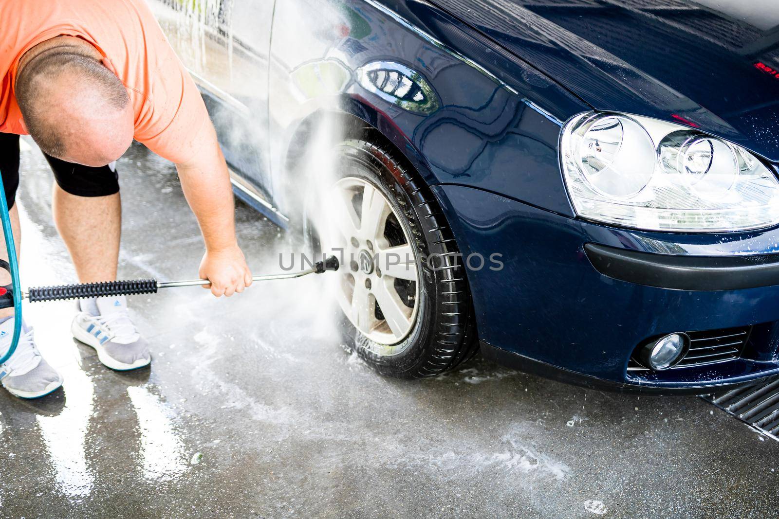 Washing and cleaning car in self service car wash station. Car washing using high pressure water in Bucharest, Romania, 2021