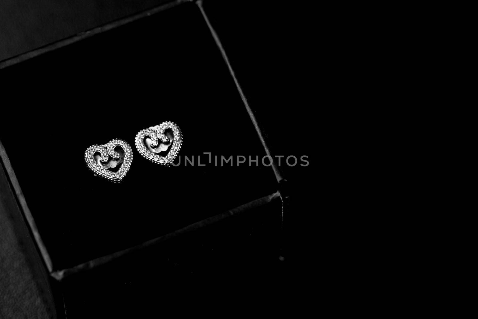 Beautiful silver earrings isolated on black, close up by vladispas