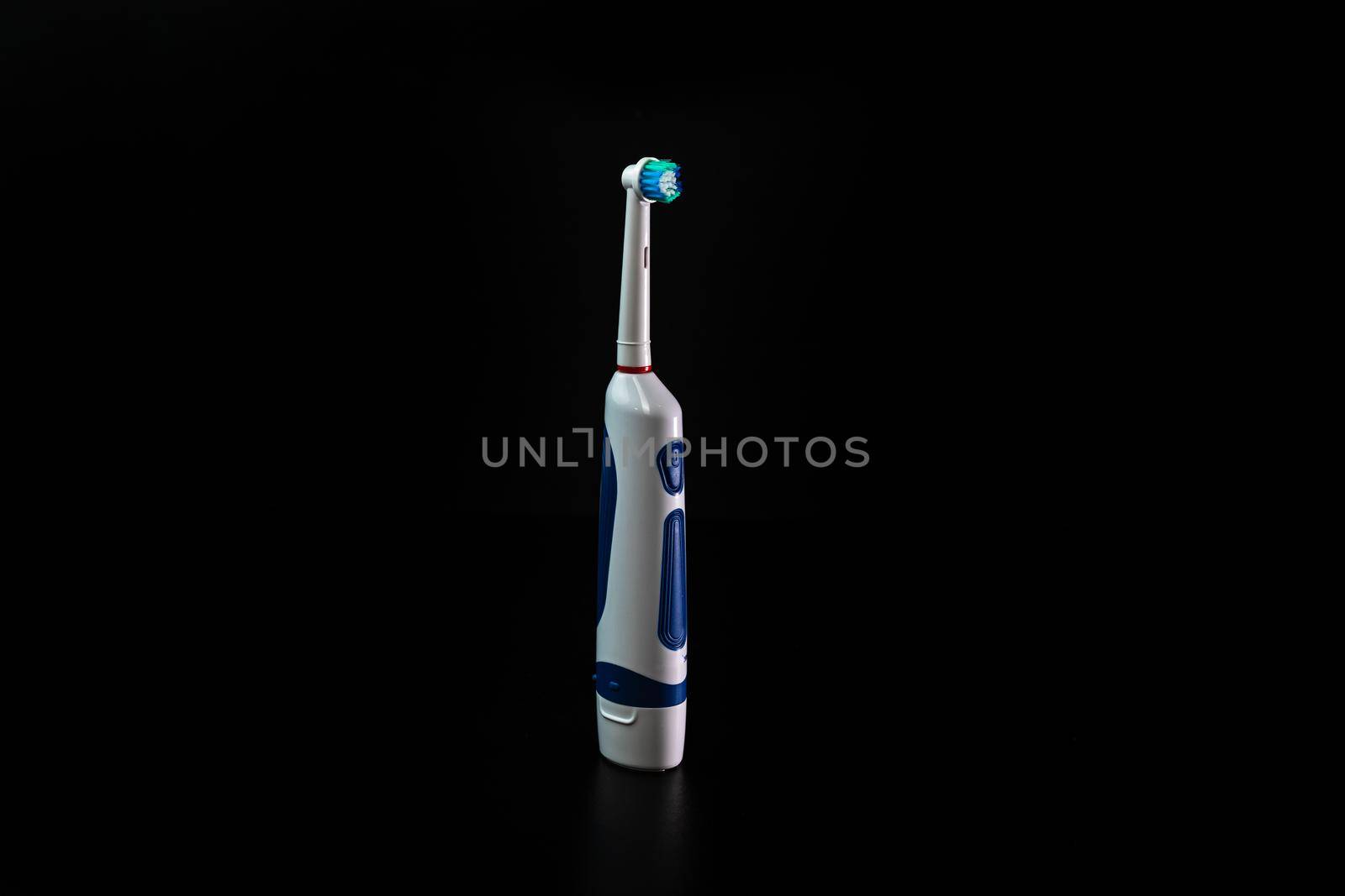 Close up of electric toothbrush isolated on black background. by vladispas