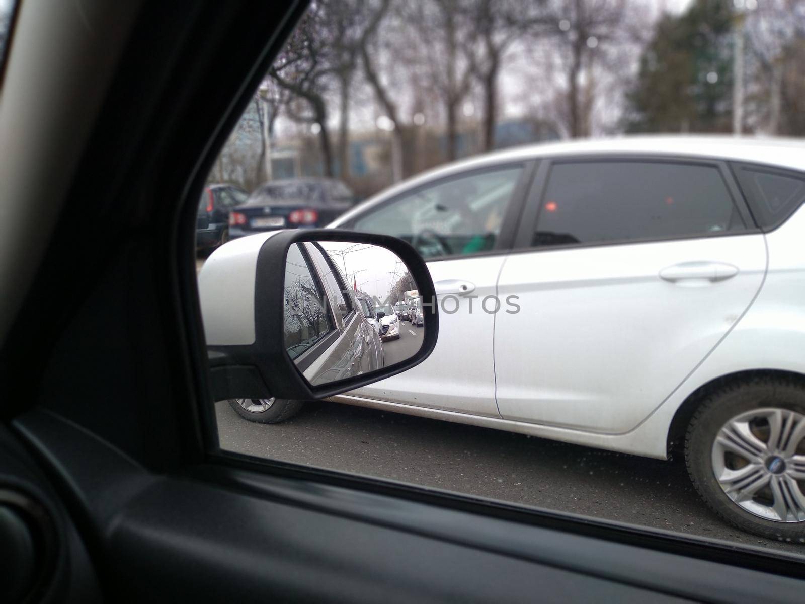 Road view through car window and mirror, cars on road in traffic in Bucharest, Romania, 2021