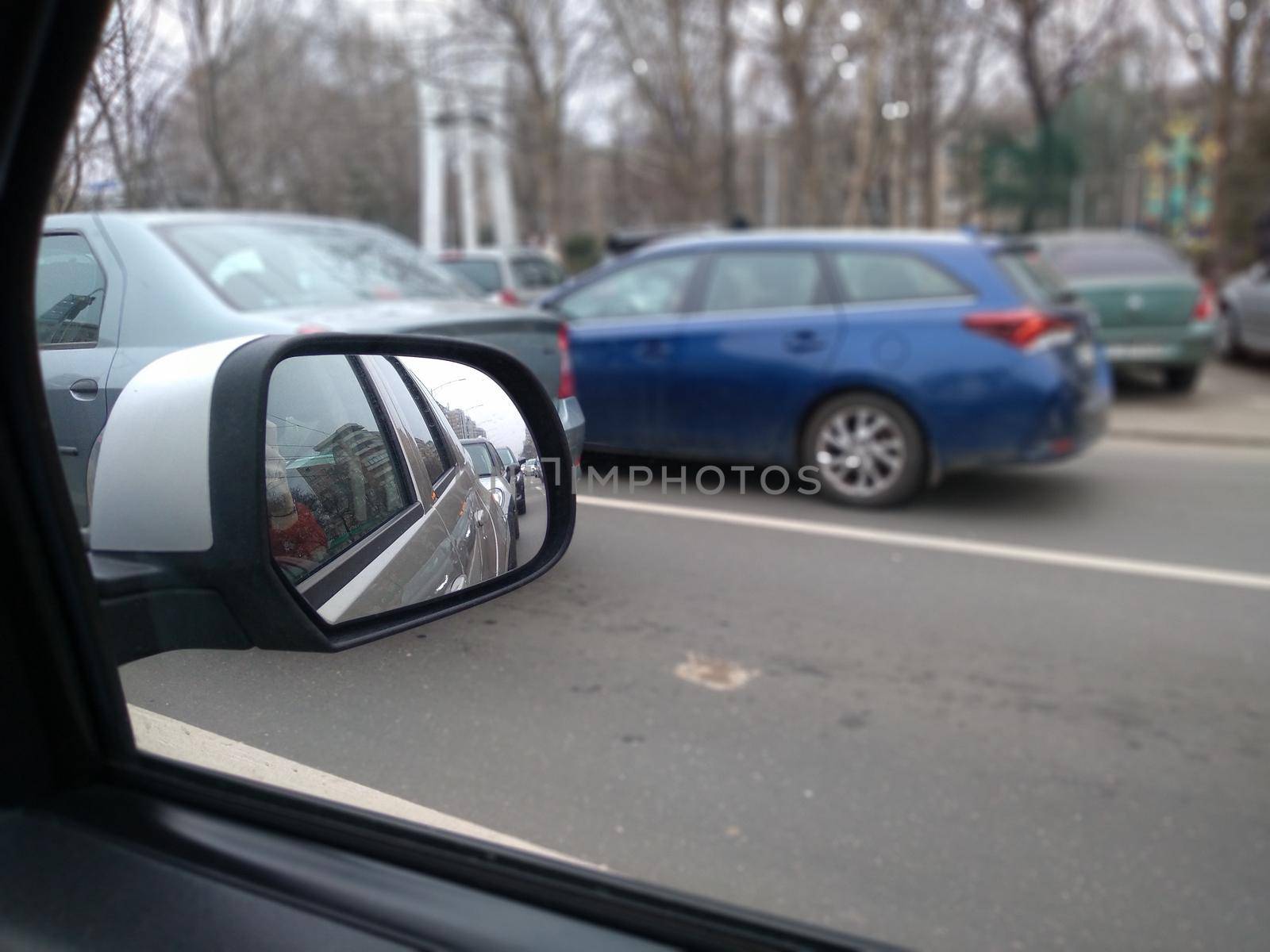 Road view through car window and mirror, cars on road in traffic in Bucharest, Romania, 2021
