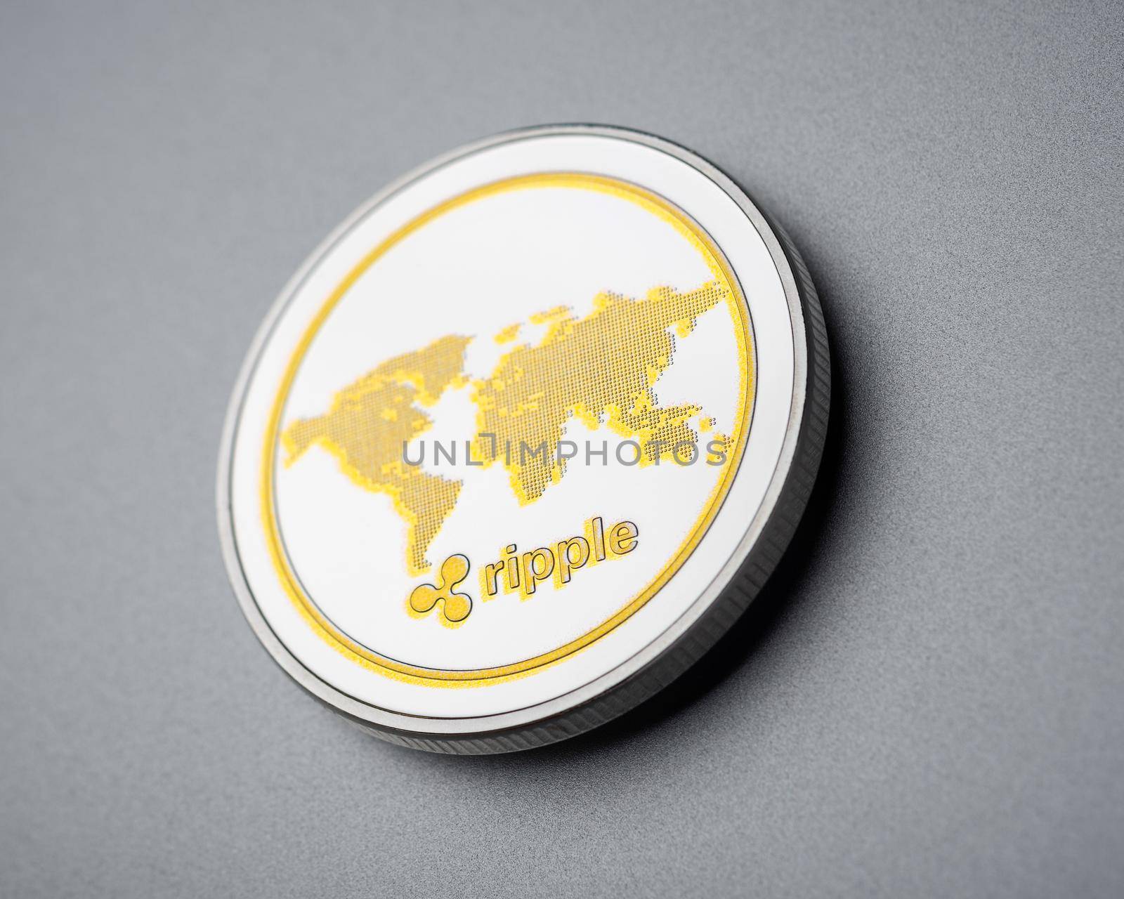 Physical cryptocurrency Ripple coin on brushed aluminium background.