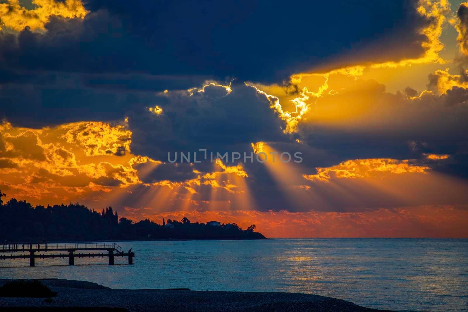 Seascape with a bright sunset and rays through the clouds.