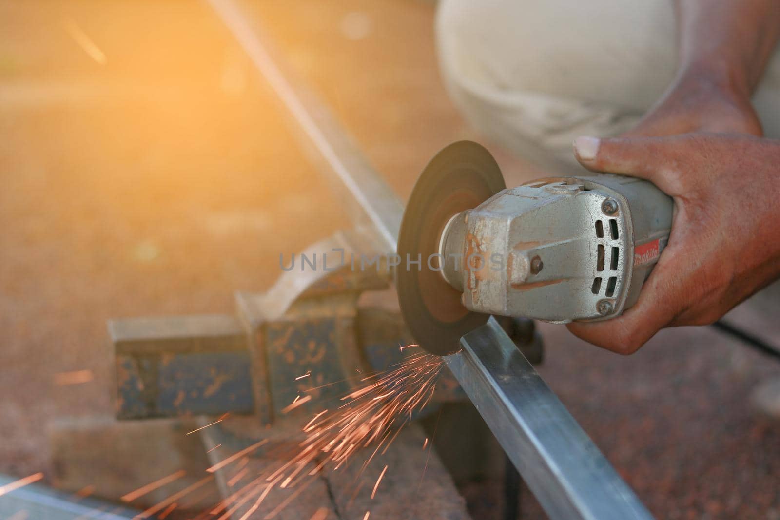 Technician cutting steel with tool in the workplace.