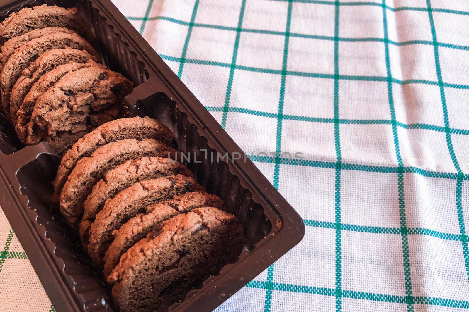 Chocolate cookies in packaging on cloth background.