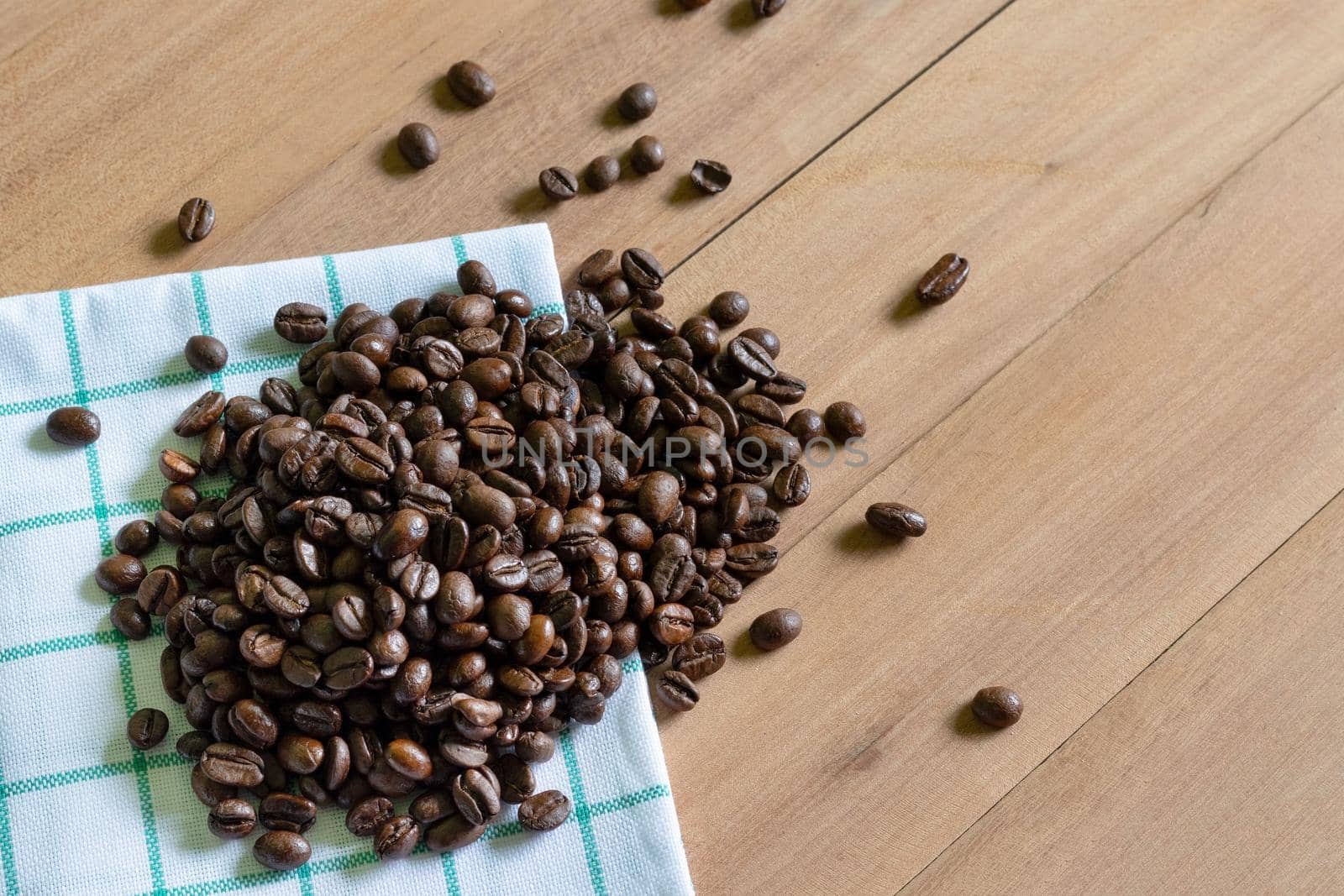 Roasted coffee beans on wooden background.