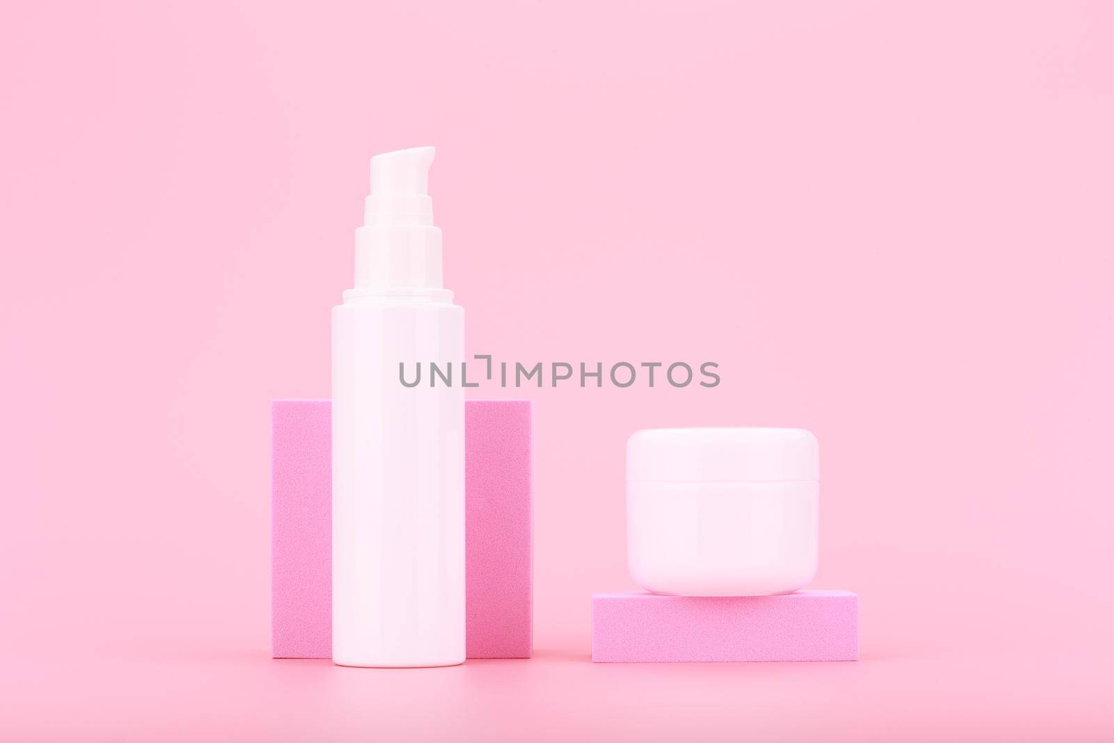 Face cream or lotion and under eye gel or cream against pink background. Concept of daily skin care, moisturizing and hydrating beauty products. 