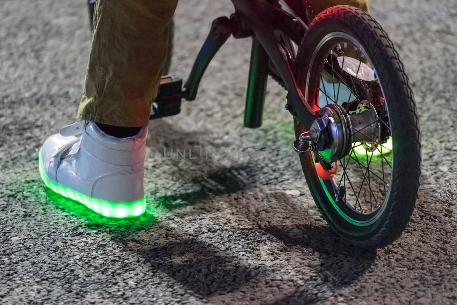 feet in shining shoes on the bike in the evening on the background of the road.