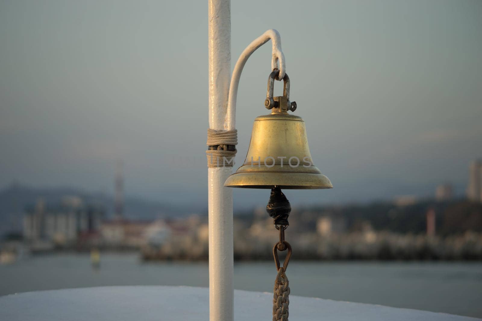 copper bell on the yacht on the background of eroded shoreline