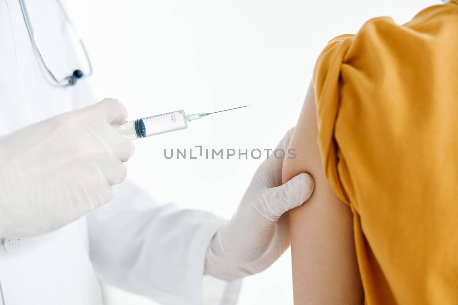 doctor giving injection to patient's shoulder close-up cropped view syringe epidemic . High quality photo